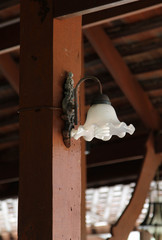 Thai old style wall lamp on the wooden pole.