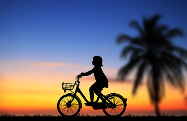 Fototapeta na wymiar silhouette happy girl ride bike on sunrise