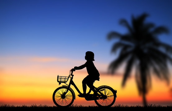 silhouette happy  girl   ride bike on sunrise