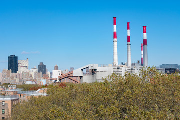 Fototapeta na wymiar Shoreline of Long Island City New York along the East River looking towards Manhattan with Smoke Stacks