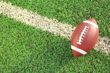 Rugby ball on green field outdoors