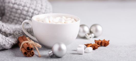 White cup with coffee and marshmallow, sweater, cinnamon. Cozy christmas composition. Hygge concept Soft focus