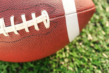 Rugby ball on green field outdoors, closeup