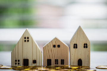 Home real estate mortgage concept : House Miniature model with stack money coins show for selling....