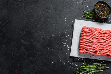 Minced marble beef. Black background. Top view. Space for text
