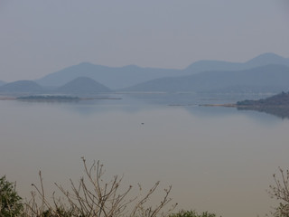 View of large lake with reflected hill and vegetation and foliage