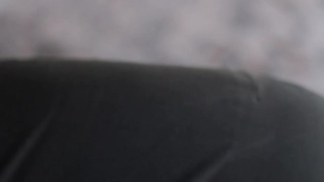 A white man loads a cartridge into a pump action shotgun holding it on his knee. HD,  close-up, no sound.