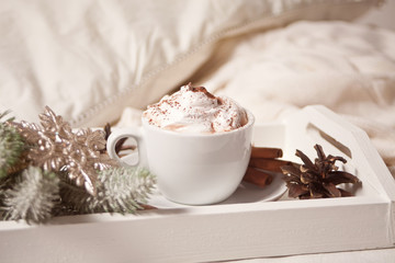 Cup of cocoa on the white tray on the bed early winter morning