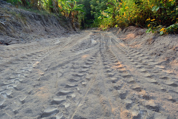 the prints of shoes and truck wheels   on the surface sand on the way to the view point in touring season at the countryside of Thailand