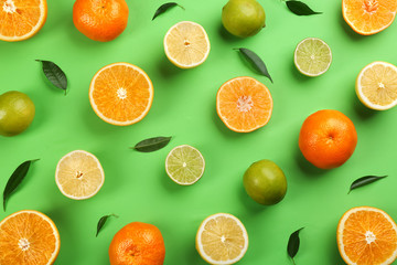 Flat lay composition with tangerines and different citrus fruits on green background