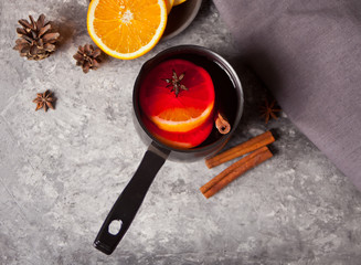 Fototapeta na wymiar Old metal pan pot of tasty mulled wine with pot with spices and orange fruits on wooden table. Top view.
