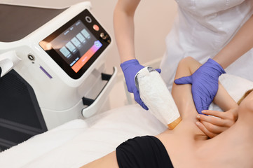 Laser epilation and cosmetology in beauty salon. Hair removal procedure. Laser epilation, cosmetology, spa, and hair removal concept. Beautiful blonde woman getting hair removing on armpits