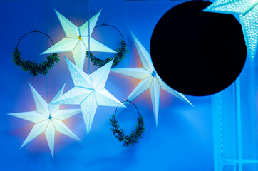 festive garland in the form of a star with light, wreaths, for Christmas, New Year, holiday on blue...