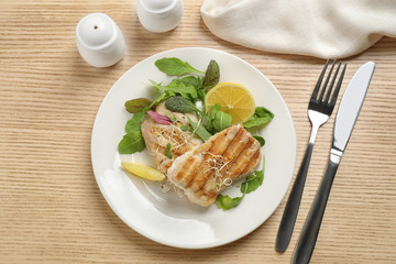 Tasty grilled fish served on wooden table, flat lay