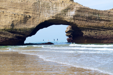 Archway into a huge rock on the shore of the ocean