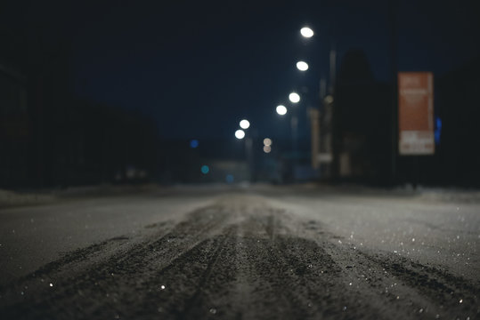 Empty snowy winter road at night time background. Blurred image.