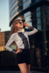 Fototapeta premium Summer portrait of a beautiful girl with long hair on the background of Moscow City
