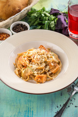 Italian pasta with zucchini, chicken and Parmesan cheese on blue wooden table