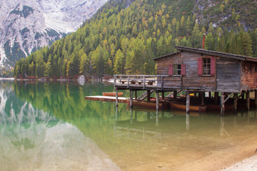 Fototapeta premium Beautiful lake Brais in the Italian Dolomites with reflection of the sky and boats on the surface