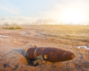 old rusty bomb  lie on a sand afrer a fairing at the sunset