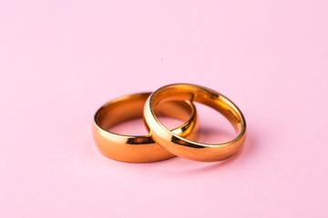 Gold Wedding Rings on Pale Pink Background