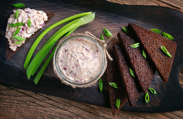 gehakte herring made with red onion in a glass jar served with fried rye bread  slices and green...