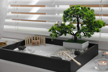Beautiful miniature zen garden and candles on window sill