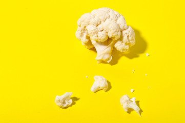 Vegetarian healthy food concept, dieting. Fresh white cleaned cauliflower on yellow background.