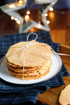 Stack of Norwegian crispy round waffles Krumkake on a tray. Concept of home rustic cooking.