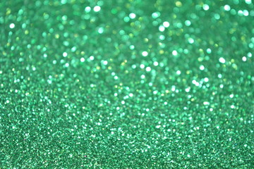Beautiful Abstract Sparkle Glitter Lights Background. Green Emerald. Shine Bokeh Effect. For party, holidays, celebration.