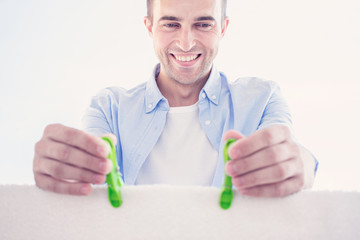 Concept cleanliness and housework. Happy man with clean towels, man hanging a wet clean towel outdoors in summer, men's hand with clothespin, closeup, toned