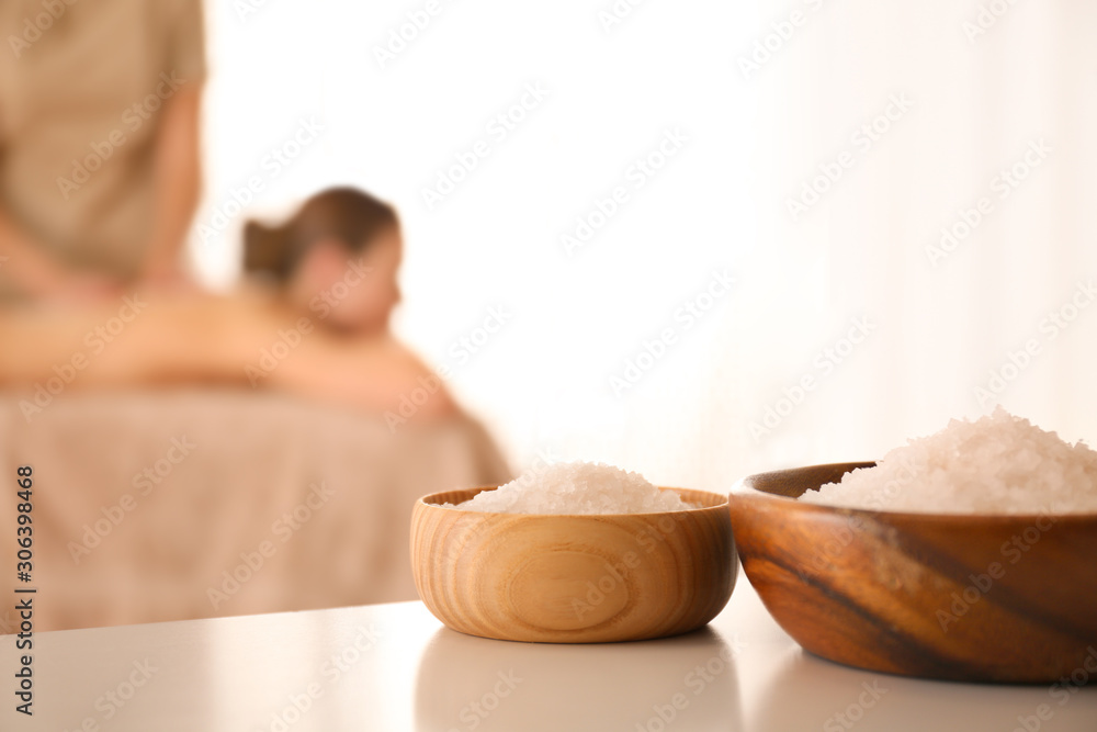 Sticker Bowls with sea salt on white table in spa salon