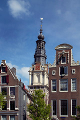 Fototapeta na wymiar View of historical, traditional buildings and Zuiderkerk church in Amsterdam. Clear blue sky background is in the background. It is a sunny summer day.