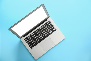Modern laptop with blank screen on light blue background, top view