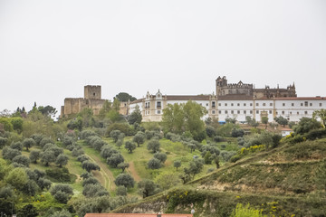 Fototapeta na wymiar Full view at the Convent of Christ, Roman Catholic convent in Tomar, typical landscape with trees and grass, originally Templar stronghold