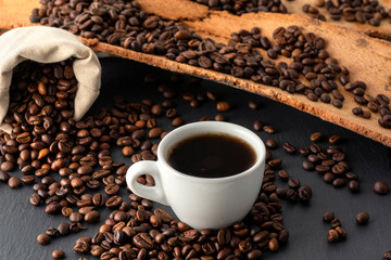 Cup of Coffee and Coffee Beans on Black Background, close-up