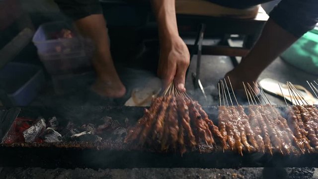 Street food vendor grilling satay, grilled meat on skewer