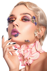 Portrait of a beautiful elegant girl with make-up and flowers on her face and a cold wave retro. Beauty, health, youth and spring concept