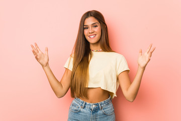 Young slim woman receiving a pleasant surprise, excited and raising hands.