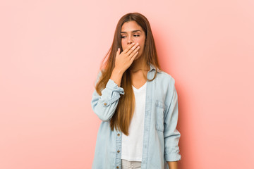 Young slim woman yawning showing a tired gesture covering mouth with hand.