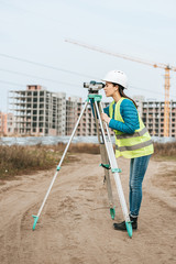 Surveyor working with digital level on dirt road