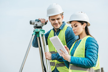 Surveyors with with digital level looking at tablet