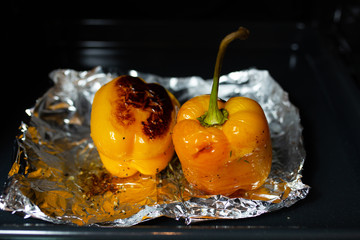 Fototapeta na wymiar Baked peppers for baking. Yellow pepper in the oven. Freshly baked yellow peppers on baking paper. Vegetarian food. Grilled vegetables