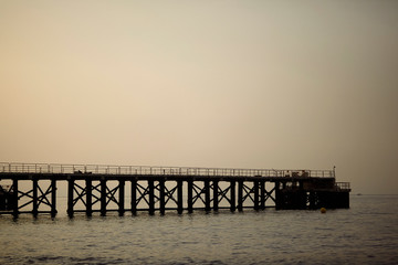 Fototapeta premium Vista a contraluz de un muelle de carga de mercancías en proceso de desmantelación a primera hora de la mañana