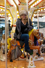 Fototapeta na wymiar attractive mature woman while having fun on a carousel of horses