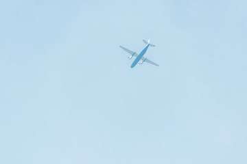 Bottom view of airplane with blue sky at background