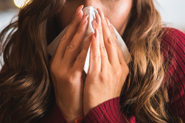 Flu cold or allergy symptom.Sick young woman  sneezing in tissue, allergies, headaches. - obrazy, fototapety, plakaty