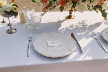 Wedding decoration table in the garden, floral arrangement, In the style vintage & rustic on outdoor. Decorated white table with yellow flowers, served for two people. Fine art laying. Family romantic