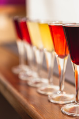 many glasses of shot or liqueur. Friends drink shot or liqueur and cheers. alcohol on blurred table background. Party and toast concept.