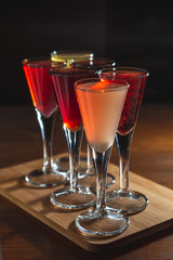 many glasses of shot or liqueur. Friends drink shot or liqueur and cheers. alcohol on blurred table background. Party and toast concept.